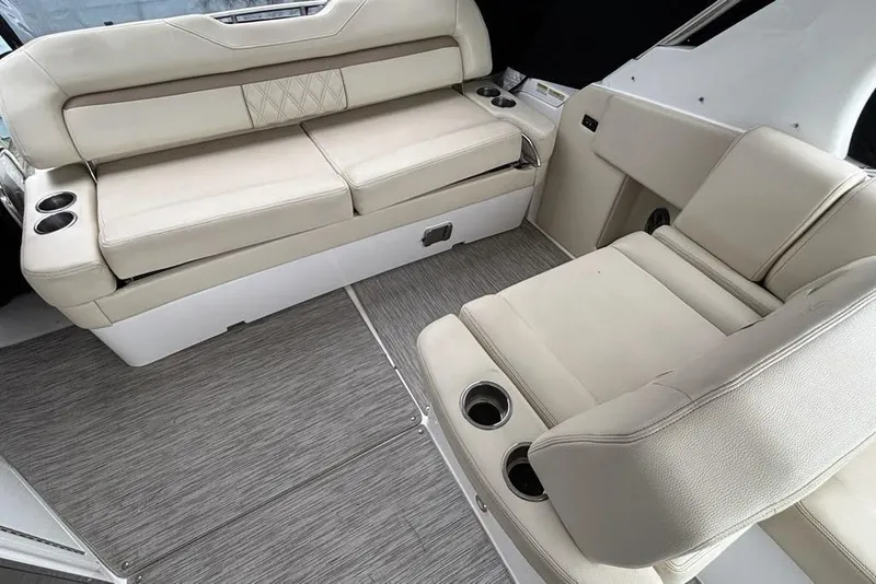 Slide: The Image of 2019 Regal 33 XO boat interior with beige seating and cup holders. - 7