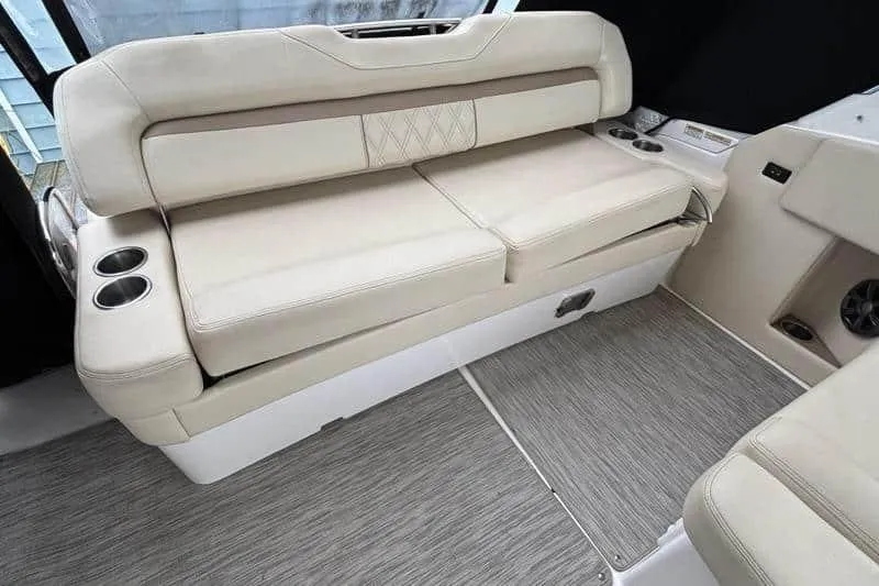 Slide: The Image of 2019 Regal 33 XO boat interior with beige seating and cup holders. - 8