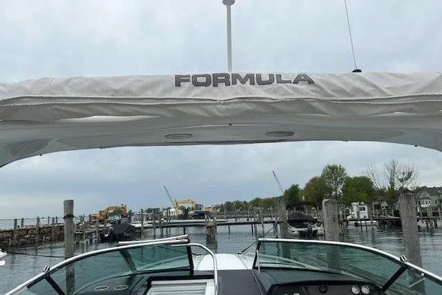Slide: The Image of 2015 Formula 310 Sun Sport boat docked at a marina with overcast sky. - 10
