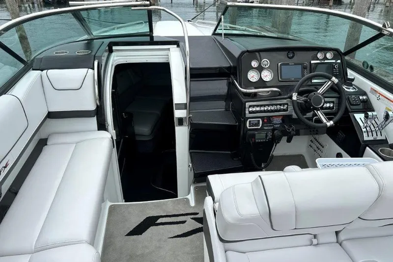 Slide: The Image of 2015 Formula 310 Sun Sport boat interior with helm, seating, and cabin entrance. - 13