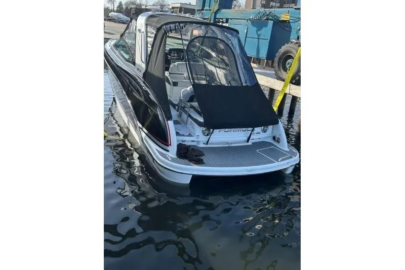 Slide: The Image of 2015 Formula 310 Sun Sport boat docked, rear view with black canopy. - 5