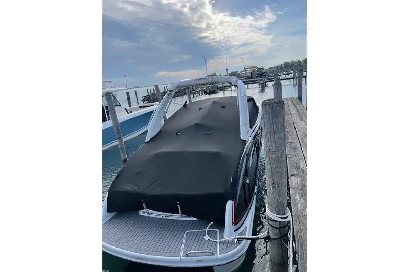 Slide: The Image of 2015 Formula 310 Sun Sport boat docked with cover, under a partly cloudy sky. - 6