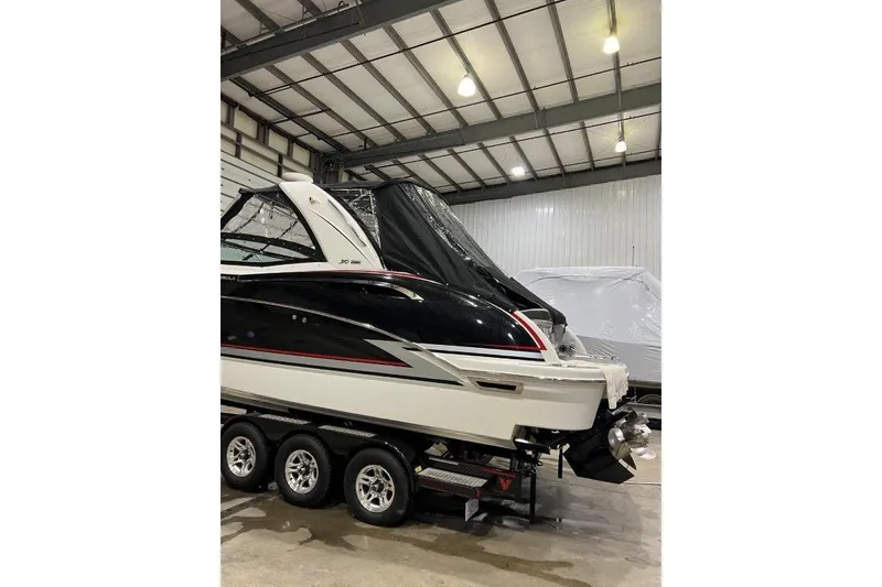 Slide: The Image of 2015 Formula 310 Sun Sport boat in storage, black and white exterior, on a trailer. - 8