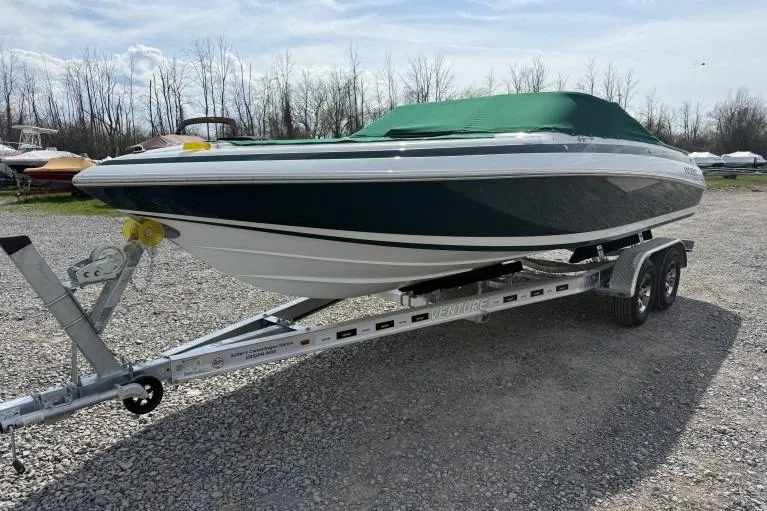 The Image of 1998 Cobalt 220 boat on trailer with green cover, parked on gravel. - 0