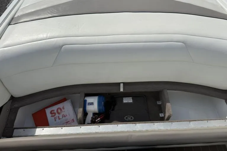 Slide: The Image of 1998 Cobalt 220 boat storage compartment with safety equipment and accessories. - 11