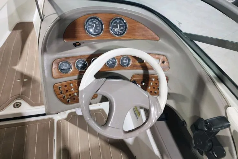 Slide: The Image of Steering wheel and dashboard of a 1998 Cobalt 220 boat with wood accents. - 4