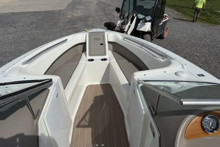 Slide: The Image of 1998 Cobalt 220 boat interior with seating and storage, parked near a utility vehicle. - 9