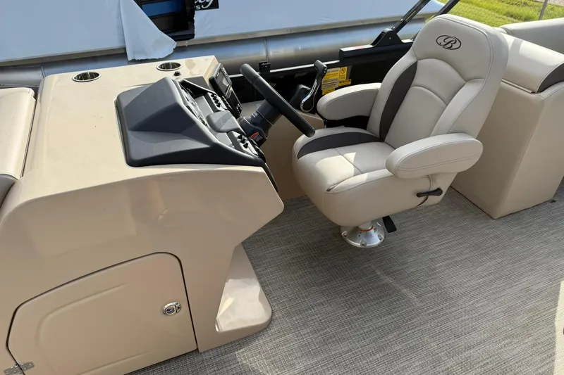 Slide: The Image of 2026 Bentley Pontoons Legacy 223 Navigator helm with beige captain's chair and control panel. - 7