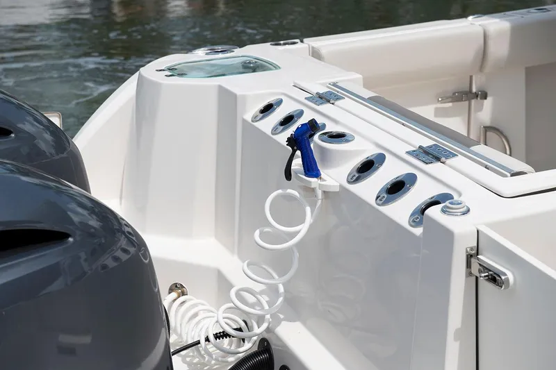 Slide: The Image of 2026 Sailfish 272 CC SE boat deck with rod holders and washdown hose. - 5