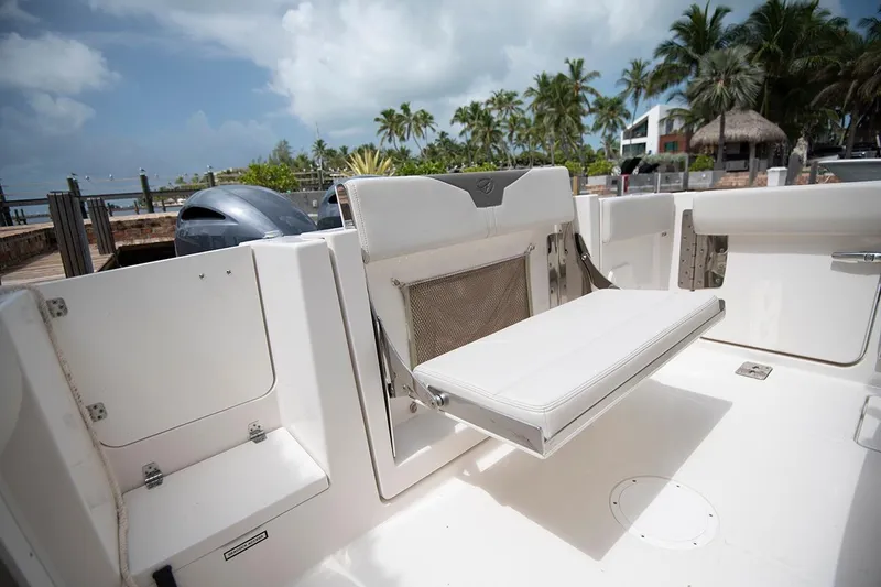 Slide: The Image of 2026 Sailfish 272 CC SE boat interior with foldable seating and scenic marina backdrop. - 9