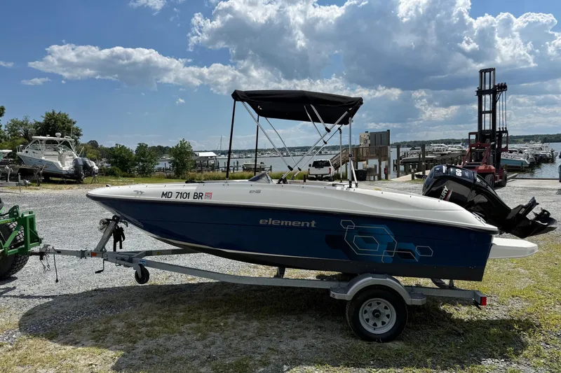 Slide: The Image of 2021 Bayliner Element E16 boat on trailer at marina under cloudy sky. - 2