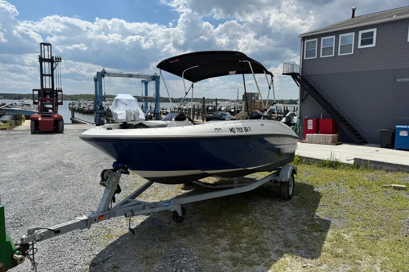 Slide: The Image of 2021 Bayliner Element E16 boat on trailer at marina, under cloudy sky. - 3