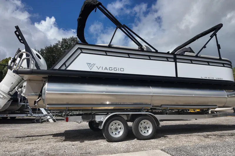 Slide: The Image of 2026 Viaggio Lago V 20 U pontoon boat on trailer under cloudy sky. - 3