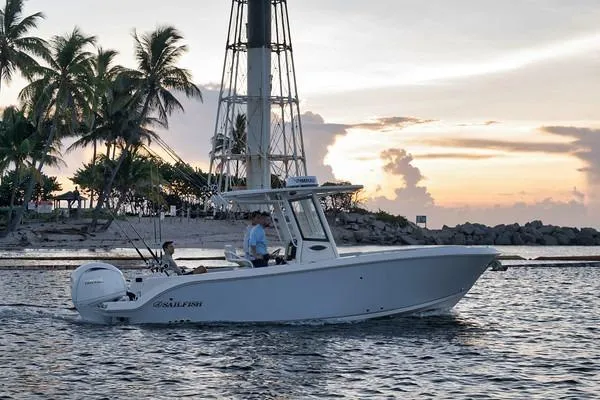 Slide: The Image of 2026 Sailfish 252 CC boat cruising at sunset near palm trees and lighthouse. - 5