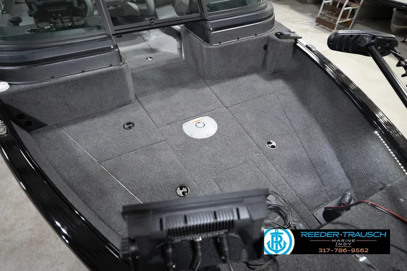 Slide: The Image of 2026 Lund 1775 Impact XS boat interior with gray carpet and fishing equipment. - 13