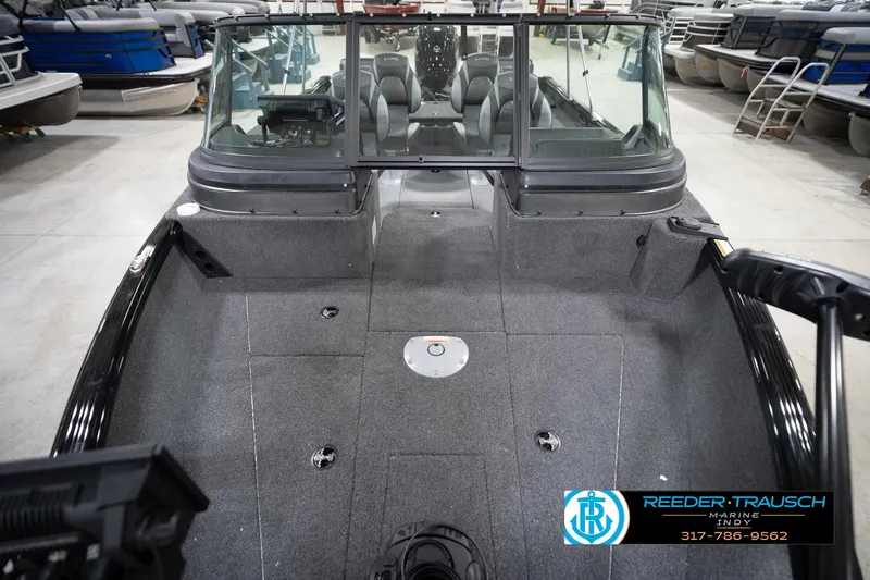 Slide: The Image of 2026 Lund 1775 Impact XS boat interior with seating and dashboard in showroom. - 19