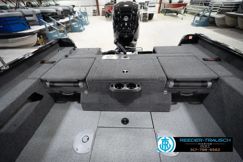 Slide: The Image of 2026 Lund 1775 Impact XS boat interior with storage compartments and motor, displayed at Reeder-Trausch Marine. - 23