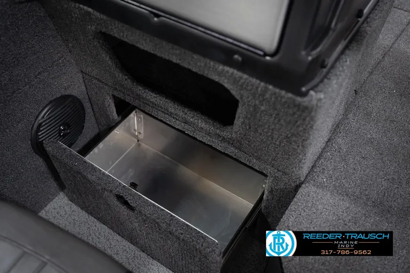 Slide: The Image of 2026 Lund 1775 Impact XS boat storage compartment with open drawer, featuring carpeted interior. - 28