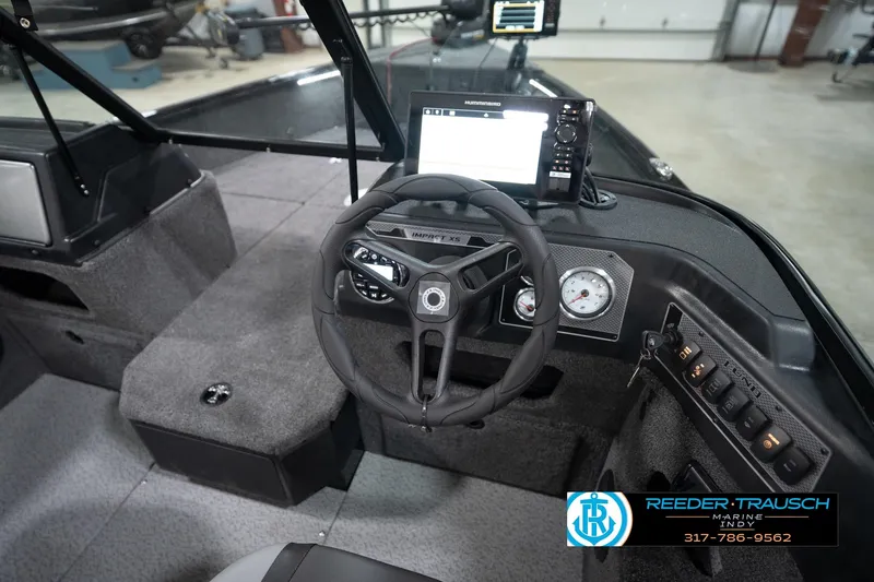 Slide: The Image of 2026 Lund 1775 Impact XS boat interior with steering wheel and control panel. - 35