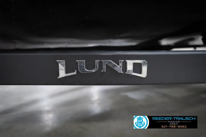 Slide: The Image of Close-up of 2026 Lund 1775 Impact XS boat logo on a dark surface. - 65