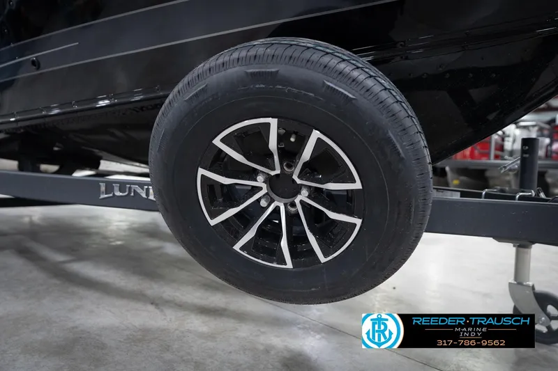 Slide: The Image of 2026 Lund 1775 Impact XS boat trailer wheel, black alloy rim, Reeder-Trausch Marine logo. - 66