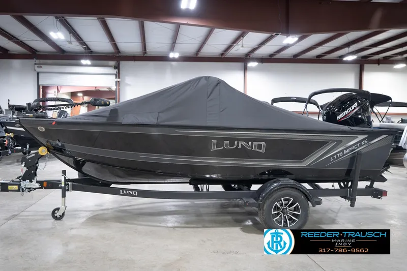 Slide: The Image of 2026 Lund 1775 Impact XS boat with cover on trailer in indoor showroom. - 67