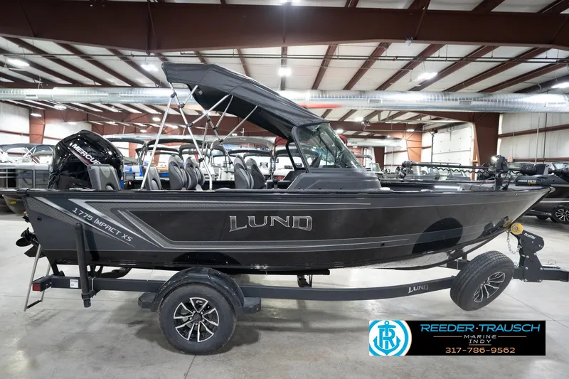 Slide: The Image of 2026 Lund 1775 Impact XS boat displayed indoors on a trailer. - 7