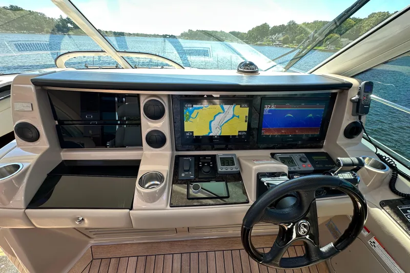 Slide: The Image of Helm of 2009 Sea Ray 60 Sundancer with navigation screens and controls on a sunny day. - 15