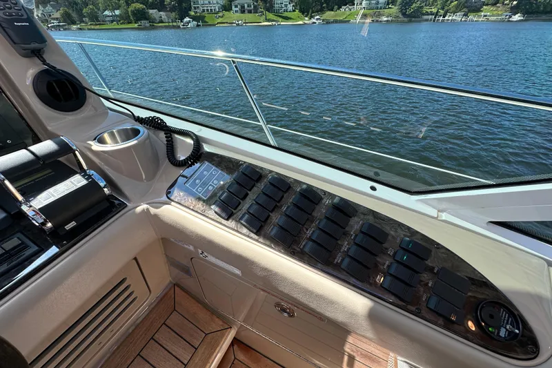 Slide: The Image of Control panel of a 2009 Sea Ray 60 Sundancer yacht overlooking a serene lake. - 17