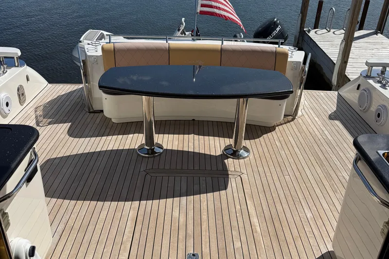 Slide: The Image of 2009 Sea Ray 60 Sundancer yacht deck with table, American flag, and water view. - 4