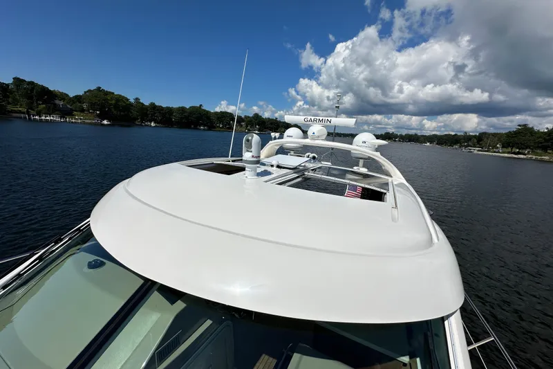 Slide: The Image of 2009 Sea Ray 60 Sundancer yacht on a serene lake under a partly cloudy sky. - 42
