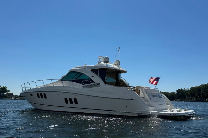 Slide: The Image of 2009 Sea Ray 60 Sundancer yacht on water, American flag waving, clear blue sky. - 45