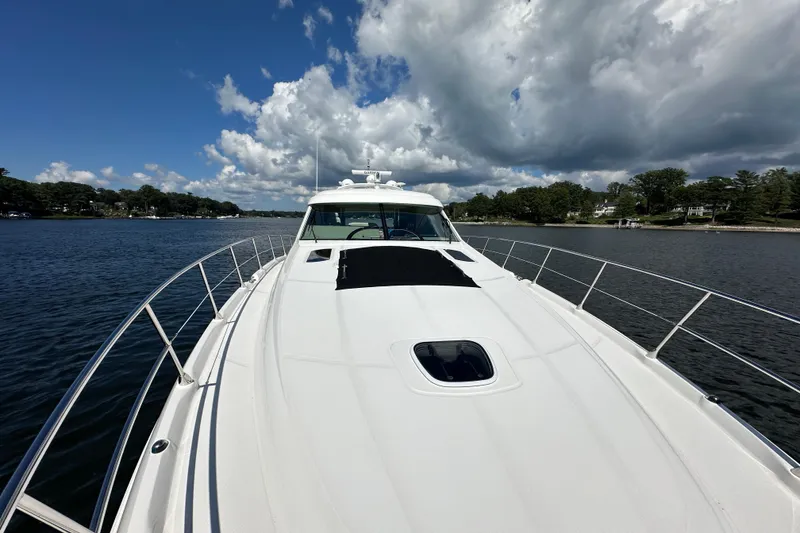 Slide: The Image of 2009 Sea Ray 60 Sundancer yacht cruising on a serene lake under a partly cloudy sky. - 48