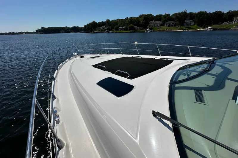 Slide: The Image of 2009 Sea Ray 60 Sundancer yacht on calm water, showcasing sleek deck design. - 49