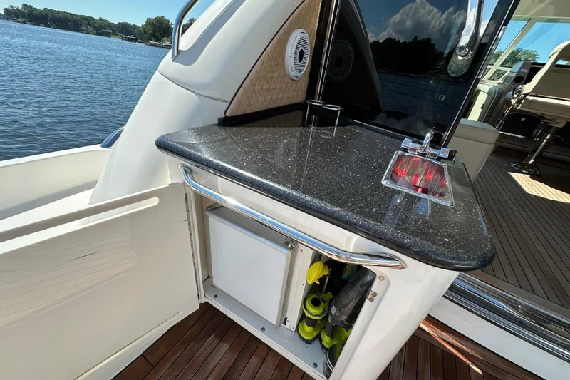 Slide: The Image of 2009 Sea Ray 60 Sundancer yacht with outdoor kitchenette and scenic lake view. - 6