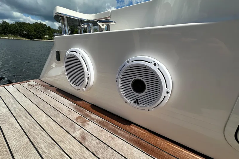 Slide: The Image of 2009 Sea Ray 60 Sundancer yacht with deck speakers, docked by a serene lake. - 8