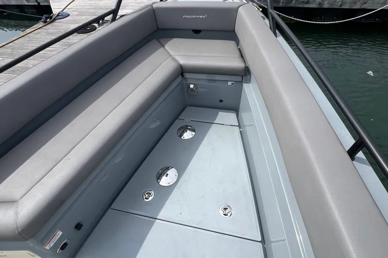 Slide: The Image of 2019 Axopar 28 CABIN boat interior with gray seating and storage compartments. - 11