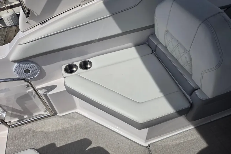 Slide: The Image of 2021 Regal 26 Express boat seating area with cup holders and speaker. - 13