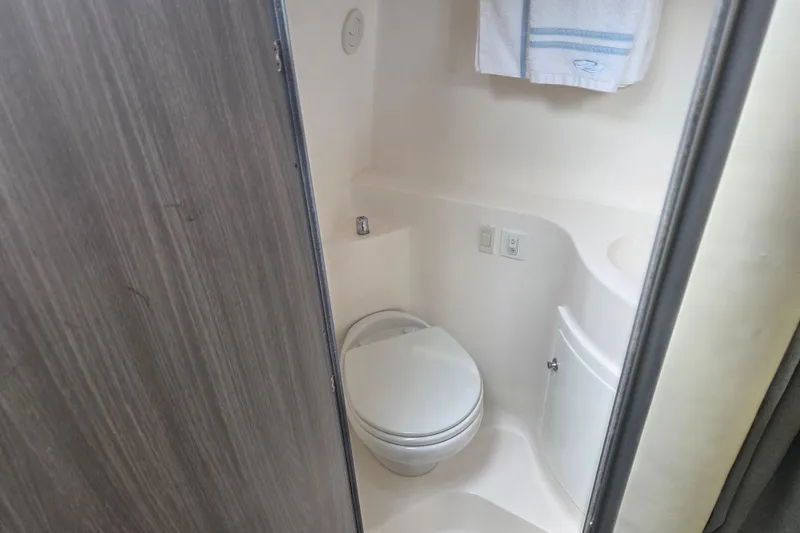 Slide: The Image of 2021 Regal 26 Express boat bathroom with toilet and towel rack. - 14