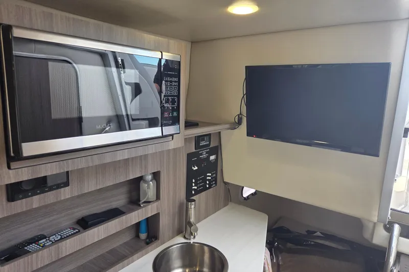 Slide: The Image of Interior of 2021 Regal 26 Express with microwave, TV, and modern amenities. - 17