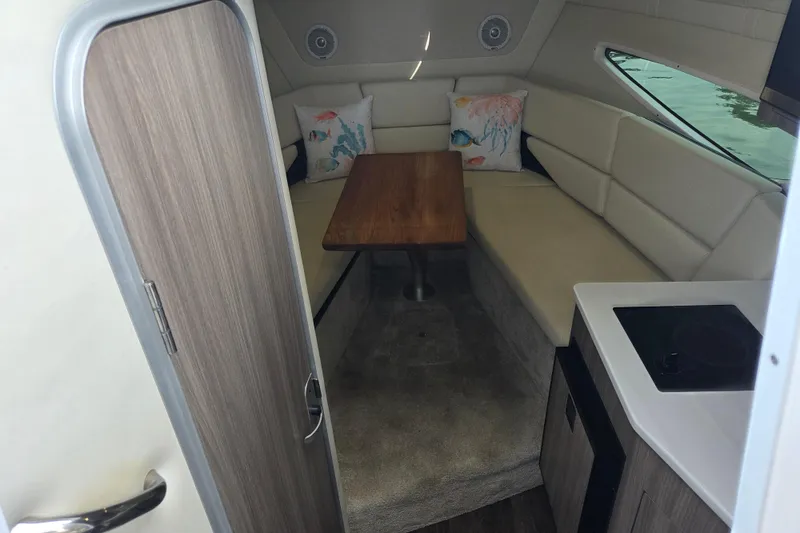 Slide: The Image of 2021 Regal 26 Express cabin interior with seating, table, and kitchenette. - 19