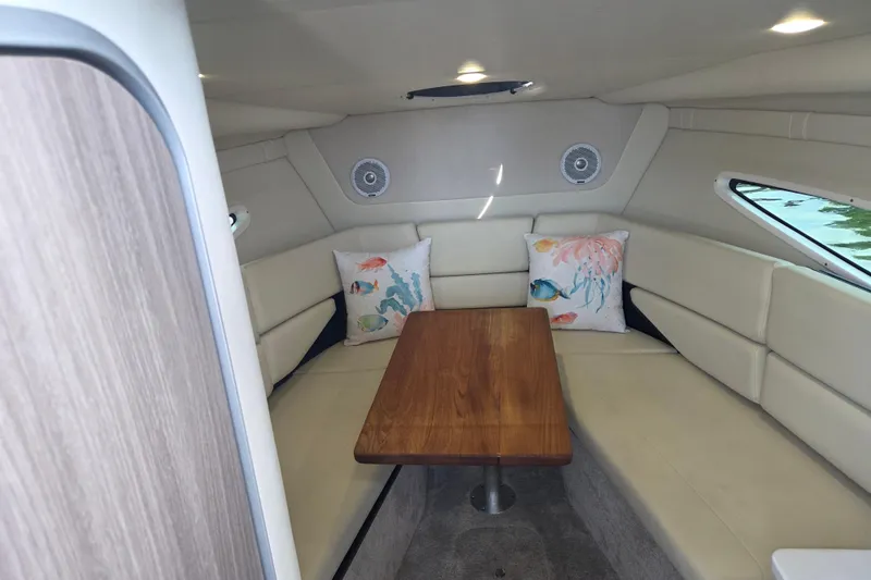 Slide: The Image of Interior of 2021 Regal 26 Express boat with cozy seating and wooden table. - 20