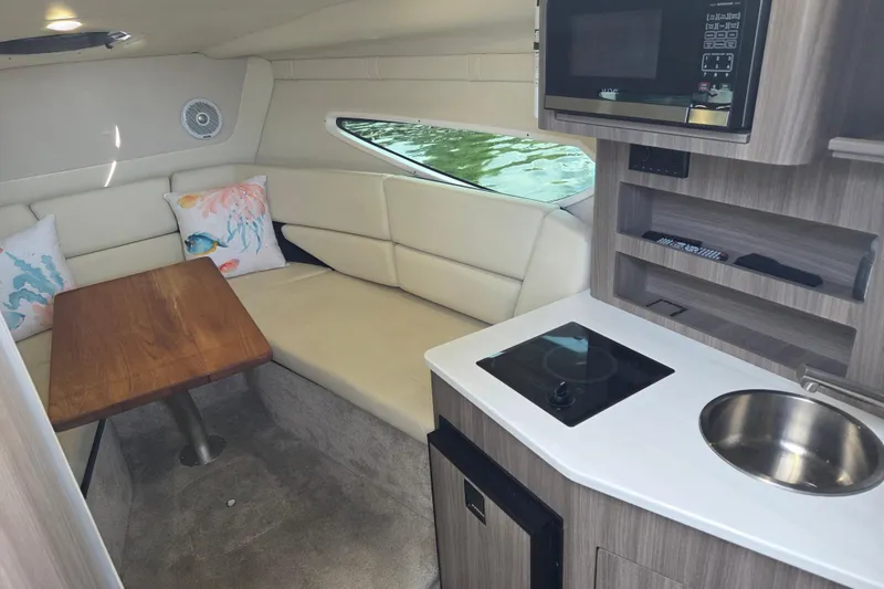 Slide: The Image of Interior of 2021 Regal 26 Express boat with kitchenette and seating area. - 21