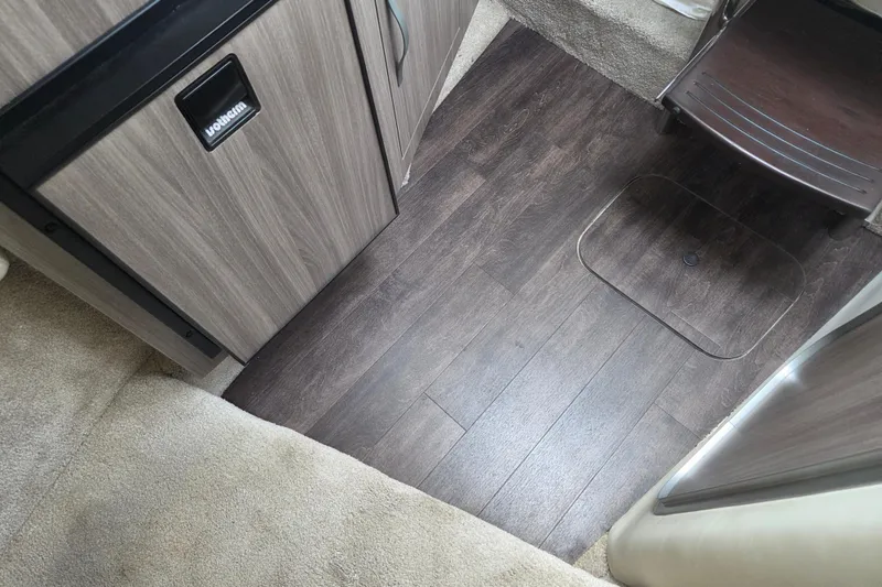 Slide: The Image of Interior of 2021 Regal 26 Express boat with wood flooring and cabinetry. - 24