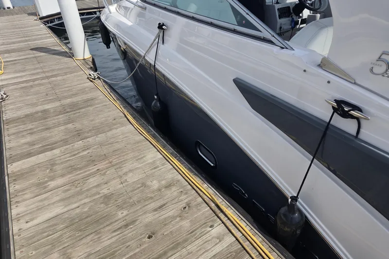 Slide: The Image of 2021 Regal 26 Express boat docked at a wooden pier, side view. - 27