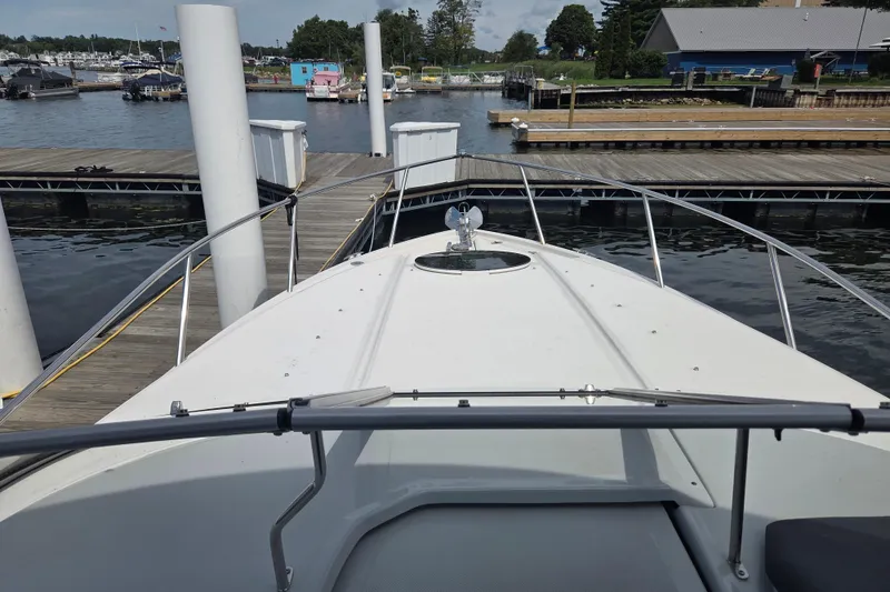 Slide: The Image of 2021 Regal 26 Express boat docked at marina with scenic waterfront view. - 31