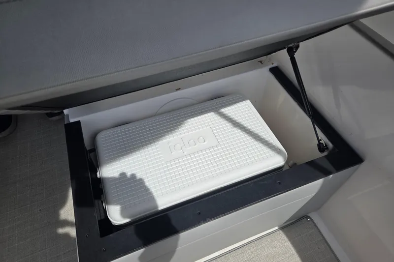 Slide: The Image of 2021 Regal 26 Express boat storage compartment with Igloo cooler inside. - 32