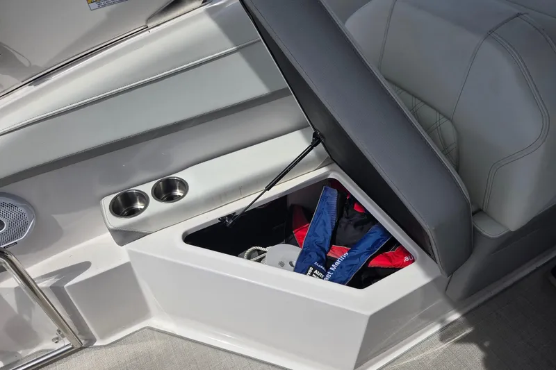 Slide: The Image of 2021 Regal 26 Express boat interior storage compartment with cup holders and life jackets. - 33
