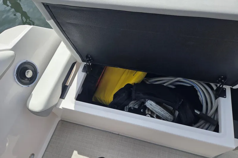 Slide: The Image of Open storage compartment on 2021 Regal 26 Express boat, containing ropes and equipment. - 34