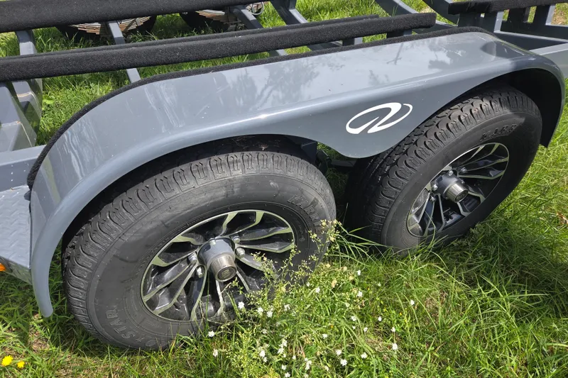 Slide: The Image of Trailer wheels of a 2021 Regal 26 Express on grass. - 39